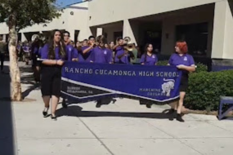 Showing school spirit and holding their banner, members of the RCHS Marching Cougars lead the Back-to-School parade.