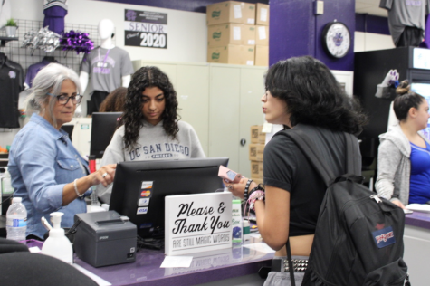 A student purchases homecoming tickets at lunch in the student store.