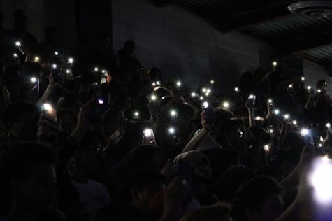 Students wave their flashlights as choir performs “I see the light” from “Tangled.