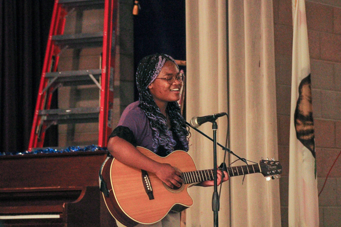 Senior Janinia Gbenoba strums the guitar as she performs at the concert.