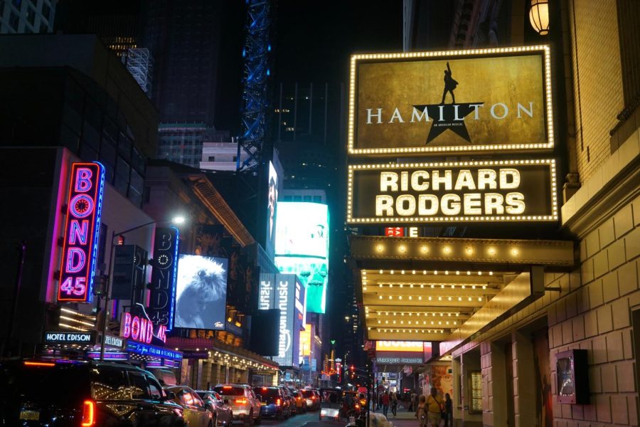 Hamilton is being presented on a sign on Broadway in New York City.