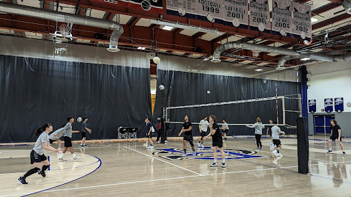 Coach Postlmayer and Coach Bill both help the new varsity volleyball team practice for their upcoming games
