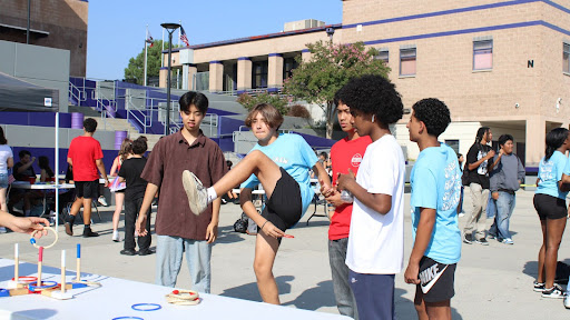 A Link Crew member plays ring toss at a table at the annual freshman tailgate.
