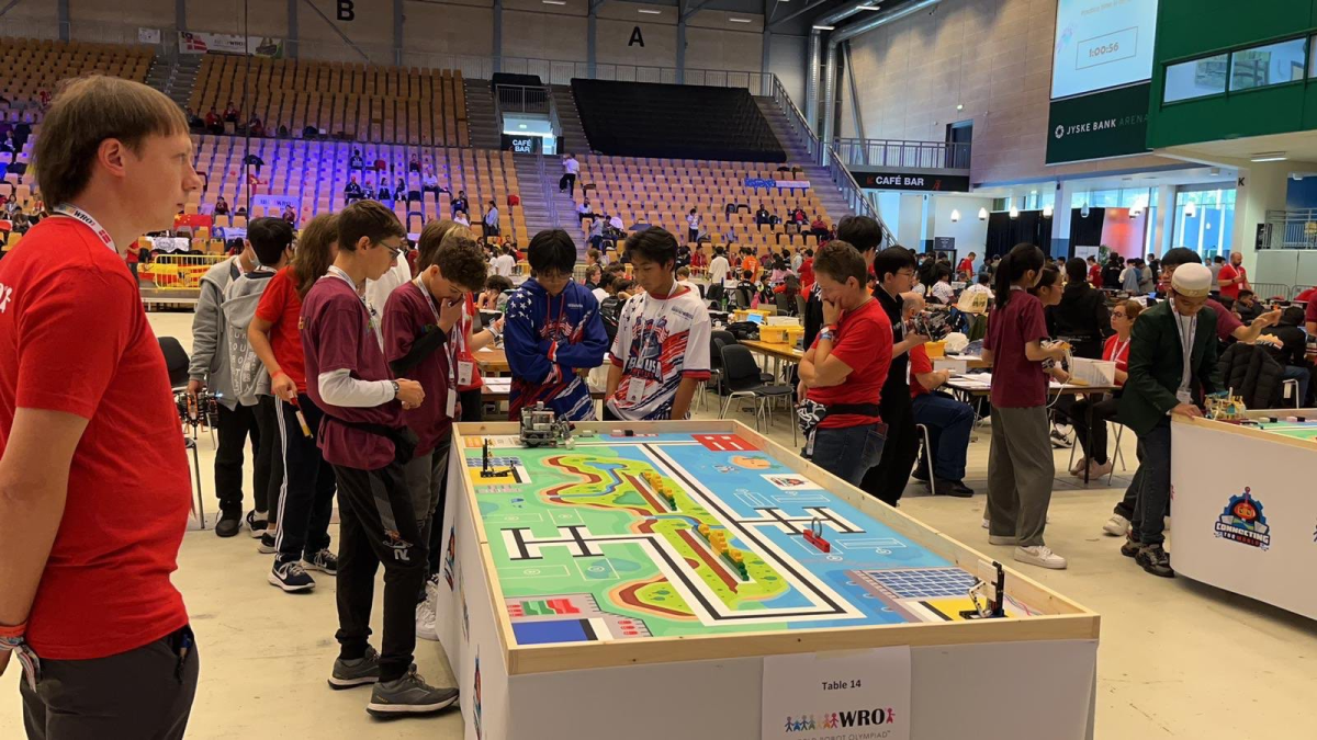 RCHS freshmen William Wu and Jack Xu (center in the blue and white shirts) watch their robot complete different tasks at the Friendship Invitational in Denmark. 