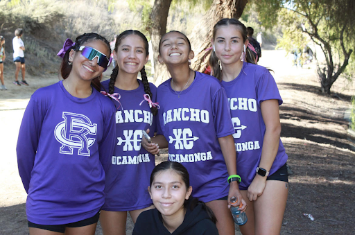 Five cross country runners pose for a picture at a meet.