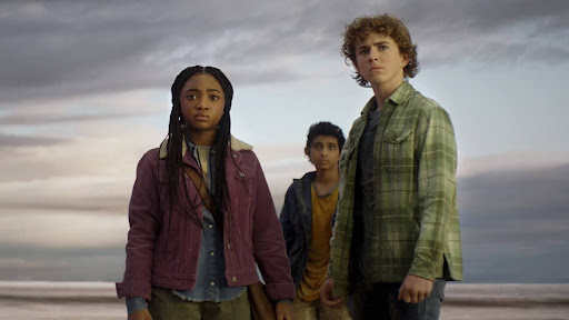 Caption: Annabeth Chase, Grover Underwood, and Percy Jackson standing on a balcony in the new show’s premiere