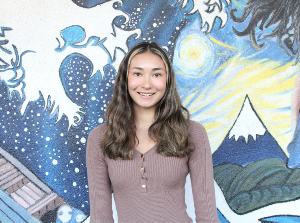  Lilah Payne poses with a smile in front of school murals.