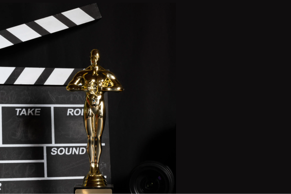 An Oscar with a slate board behind it. (Graphic made in Canva).
