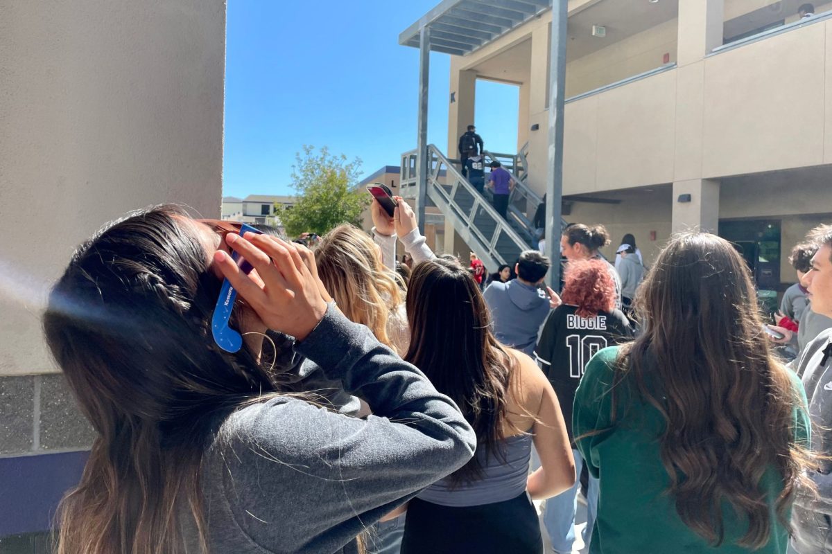 Senior Kaithlyn Aguirre uses protective glasses to view the solar eclipse on Monday, April 8. 