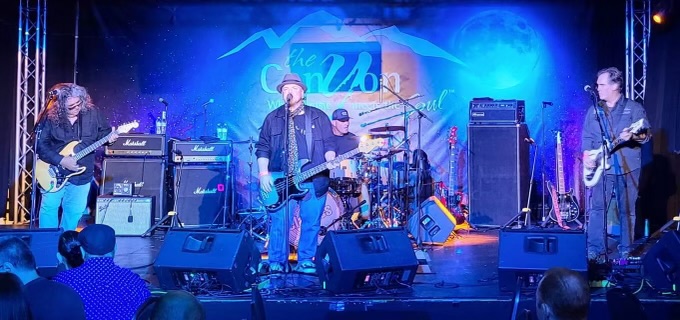 Jason Arthur and his fellow band-mates playing on stage at a show. 