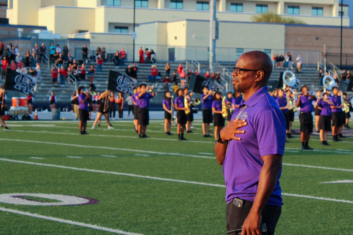 Principle Aikens places his hand over his heart for the National Anthem at the start of the first home football game.