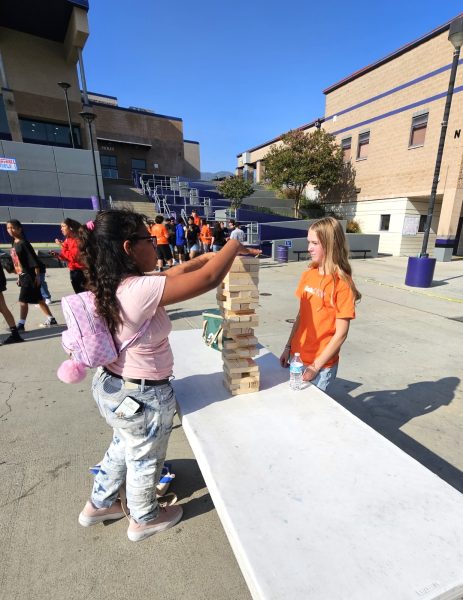 Junior Link Crew member Sydney Thompson helping out a  freshman at freshman tailgate. 