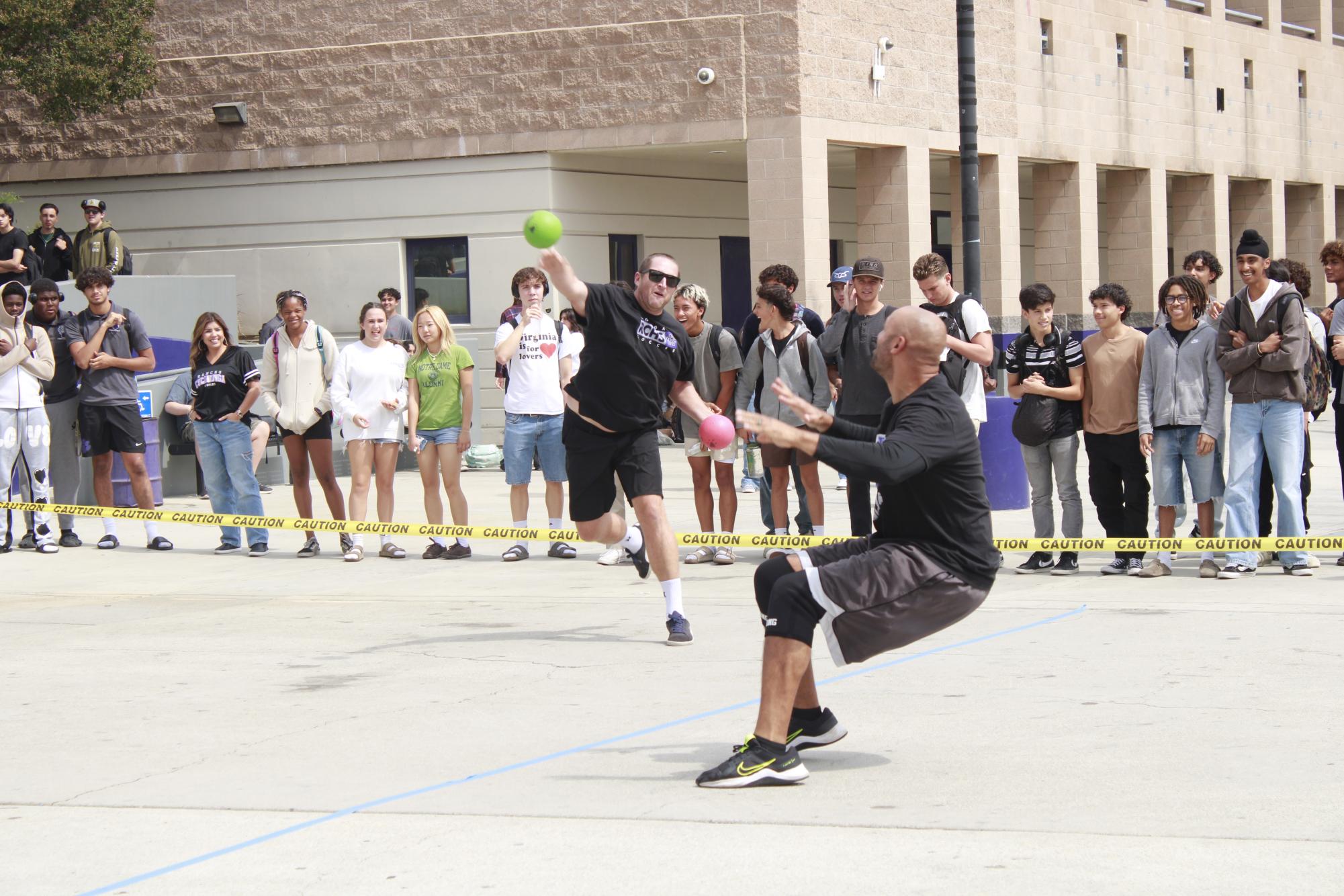 Mr. Matt Garner aims to hit Mr. Benjamin Sankey with the dodgeball.