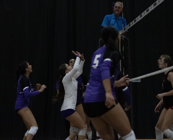 RCHS girls' volleyball team ready themselves to hit the ball over the net.