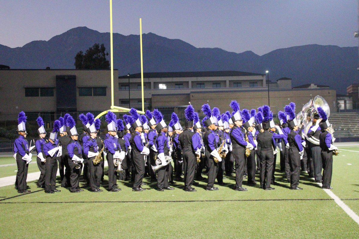 Band students wait for their cue to march across the football field.