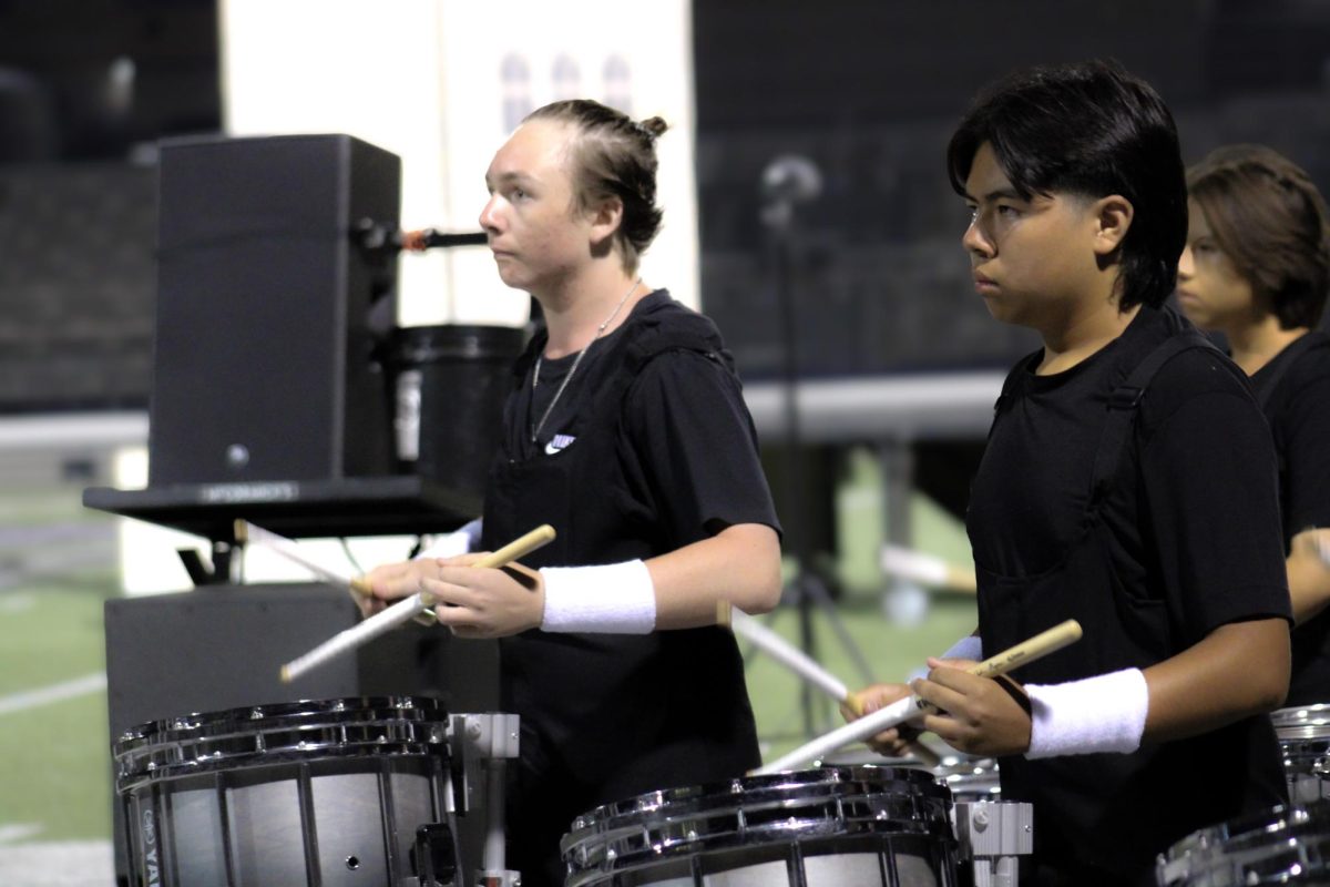 Derek Rowlette and Isaiah Valtier play snare for audience.