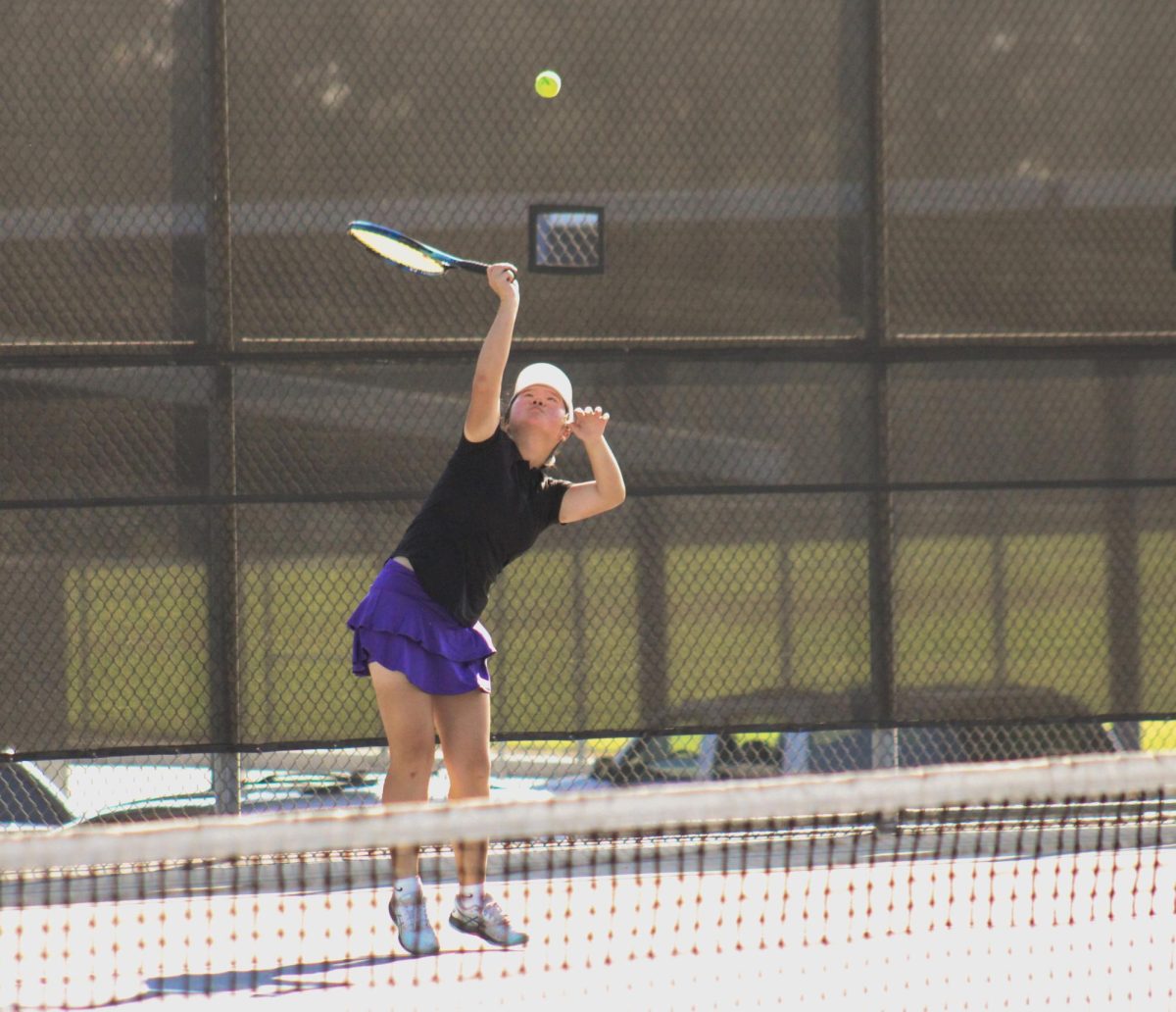 Senior Emily Shao serves a tennis ball.