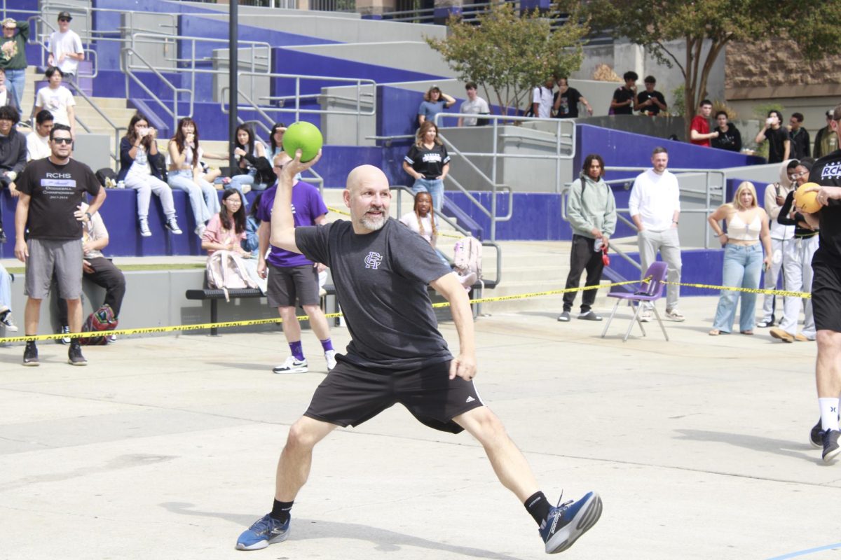 Mr. Jared Derksen throws the ball to try to hit his opponent in the annual staff dodgeball game. 