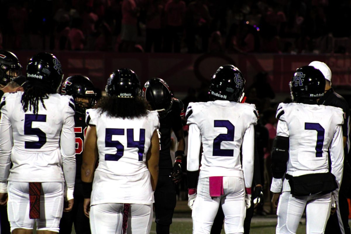 Rancho Cucamonga's captains shake hands with players from Etiwanda High School before the pink out game.