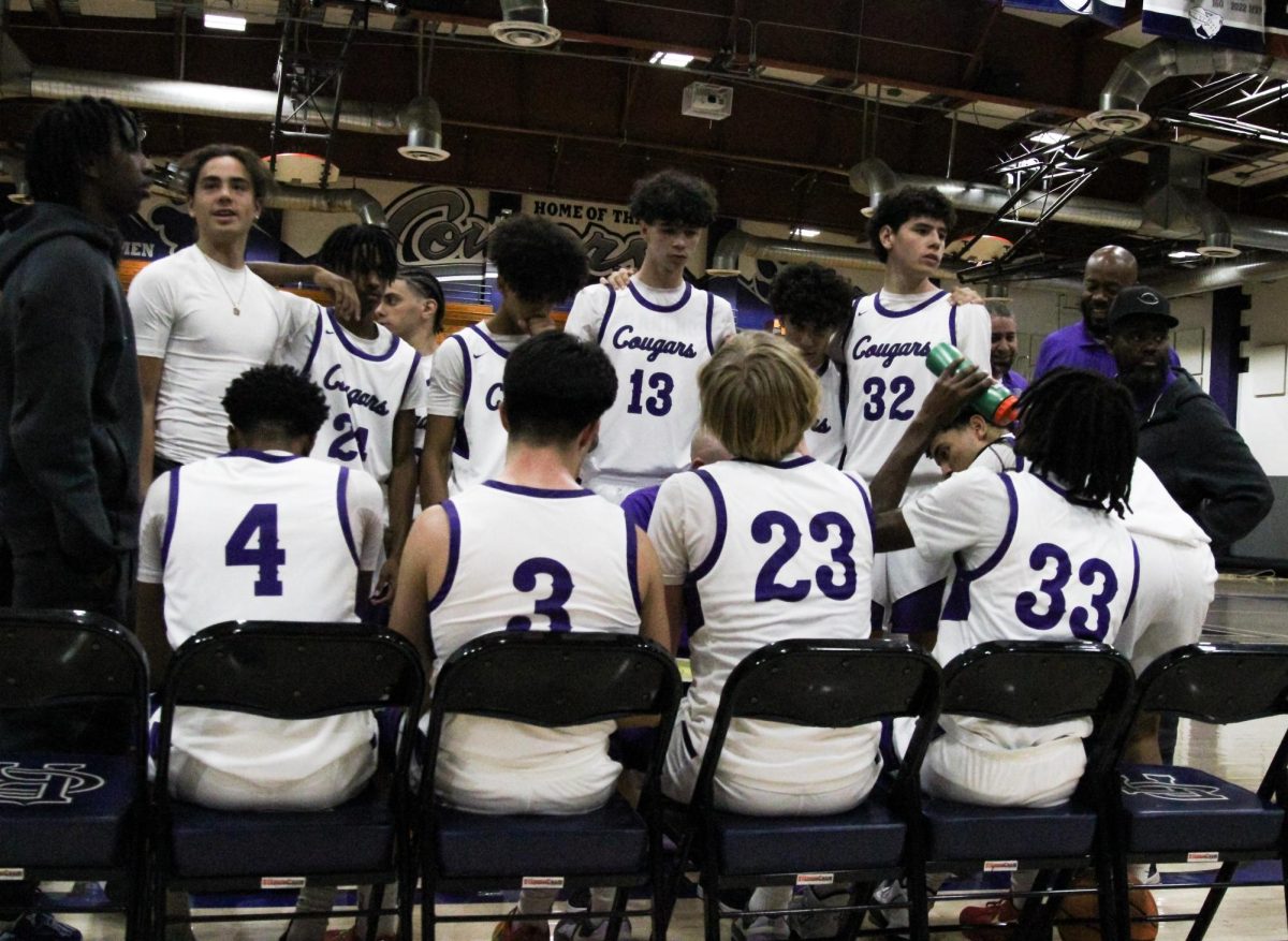 The RCHS varsity team huddles up during a timeout against Arlington High School.