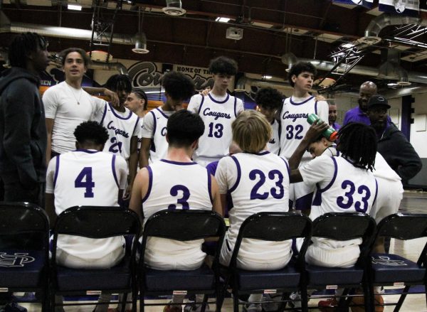 The RCHS varsity team huddles up during a timeout against Arlington High School.