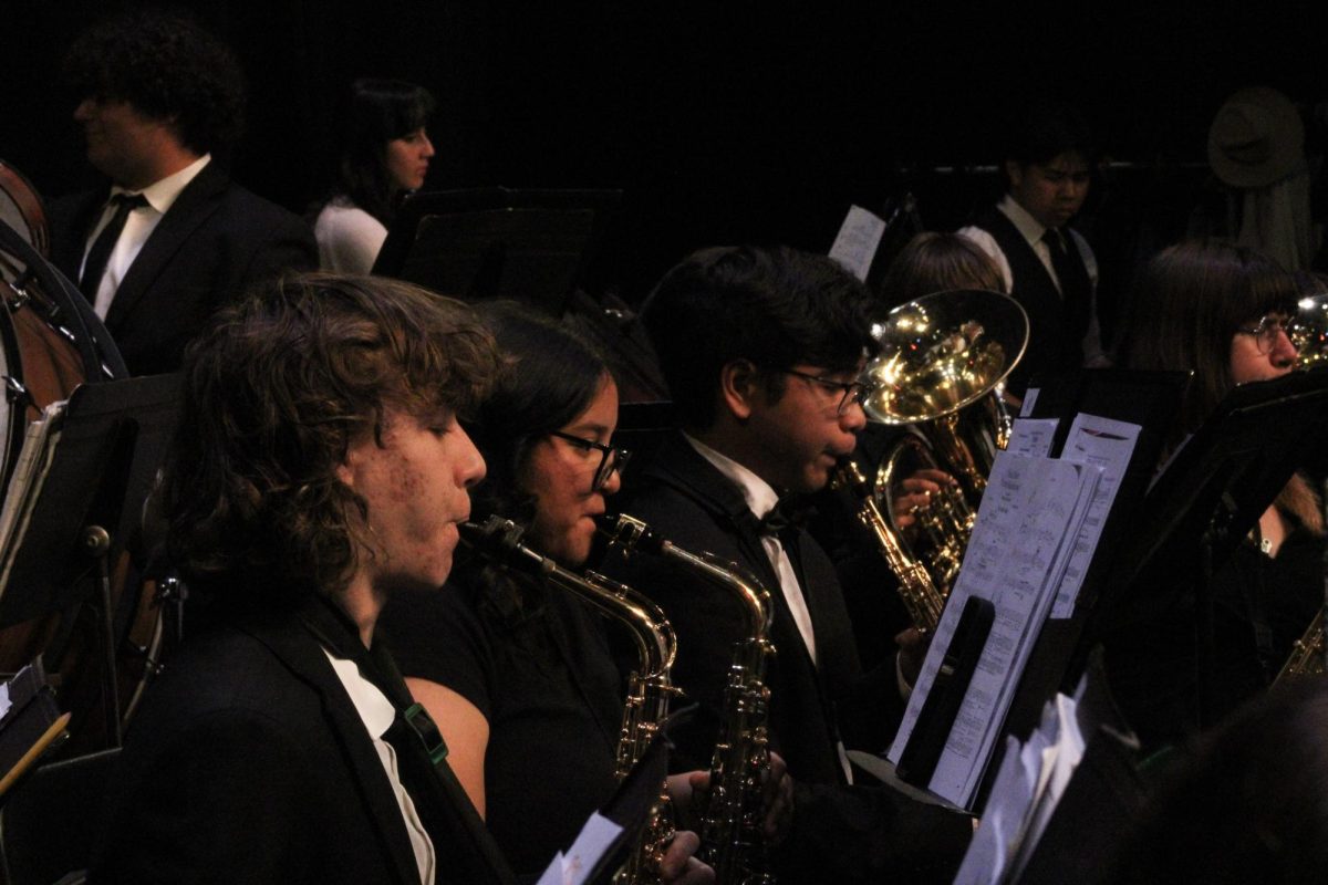 Saxophones of the wind ensemble warm up together before their performance.