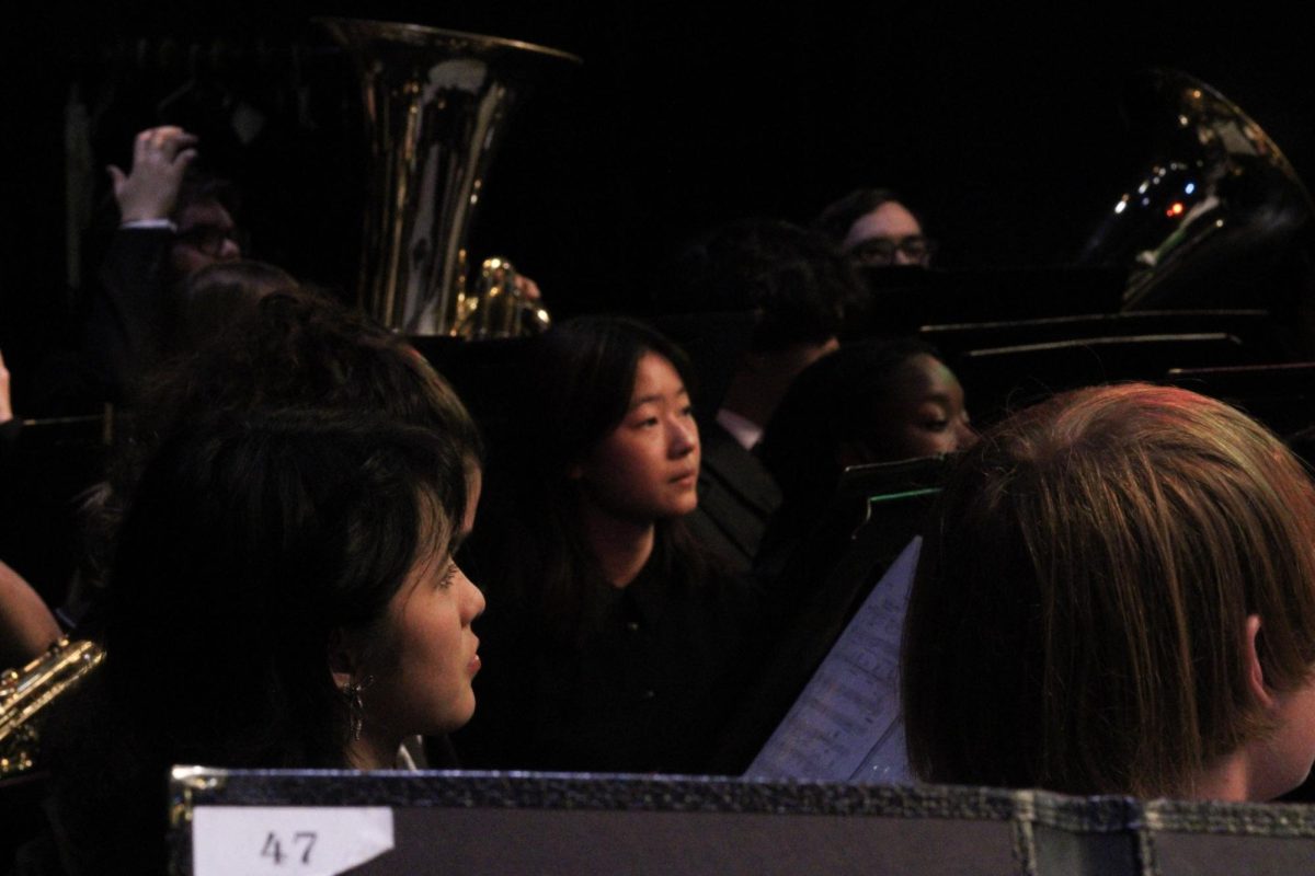 Members of the wind ensemble listen to Mr. James Ana, the band director, as he gives words of wisdom before the closing wind ensemble performance.