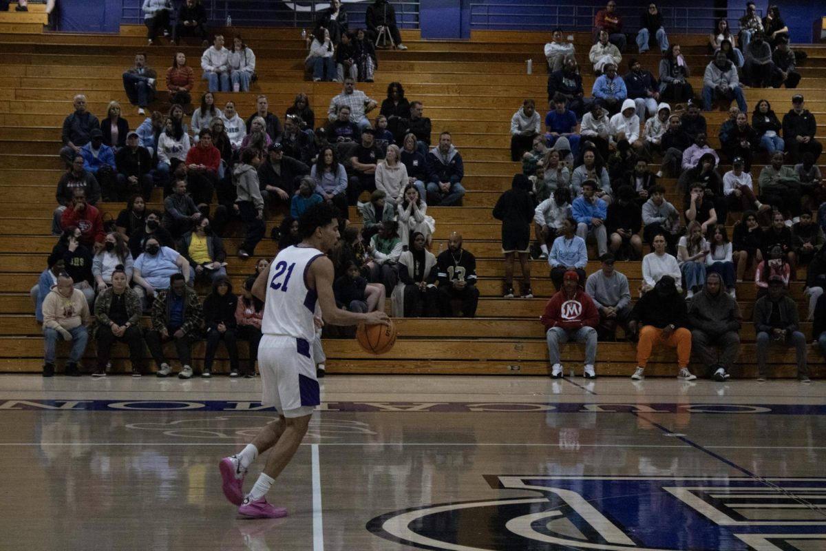 Senior Aaron Glass dribbles the ball down the court.