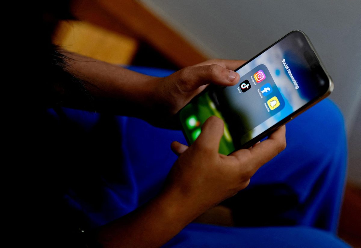 A high school student poses with her mobile showing her social media applications in Melbourne, Australia, November 28, 2024. REUTERS/Asanka Brendon Ratnayake