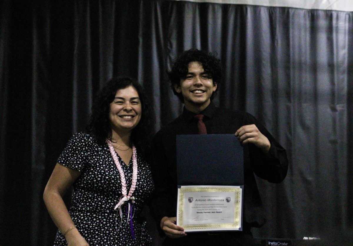 Junior, Antonio Monterroza, is presented the "Woody Herman" jazz award and takes a photo with his instructor Mrs. Susana Quinteros