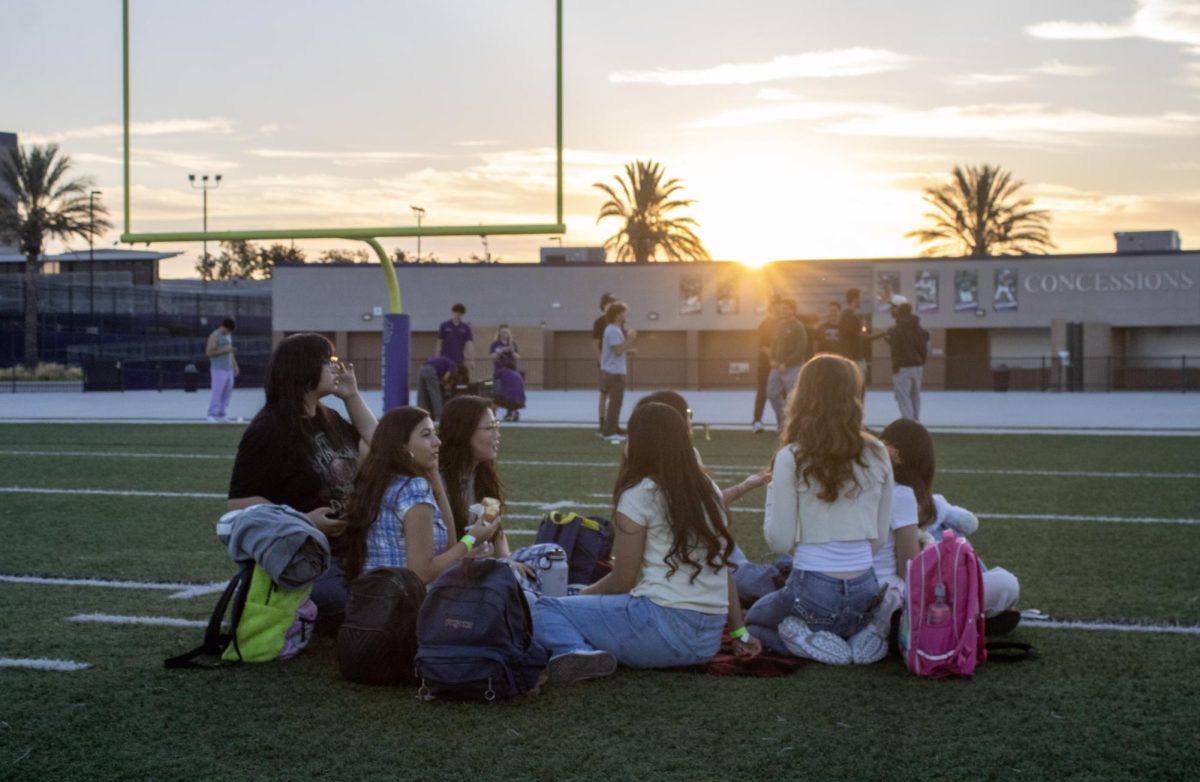 Groups of seniors gather with their friends on the Cougar Stadium's field to watch the sun begin to light up the sky at senior sunrise on Friday, Aug. 22.
