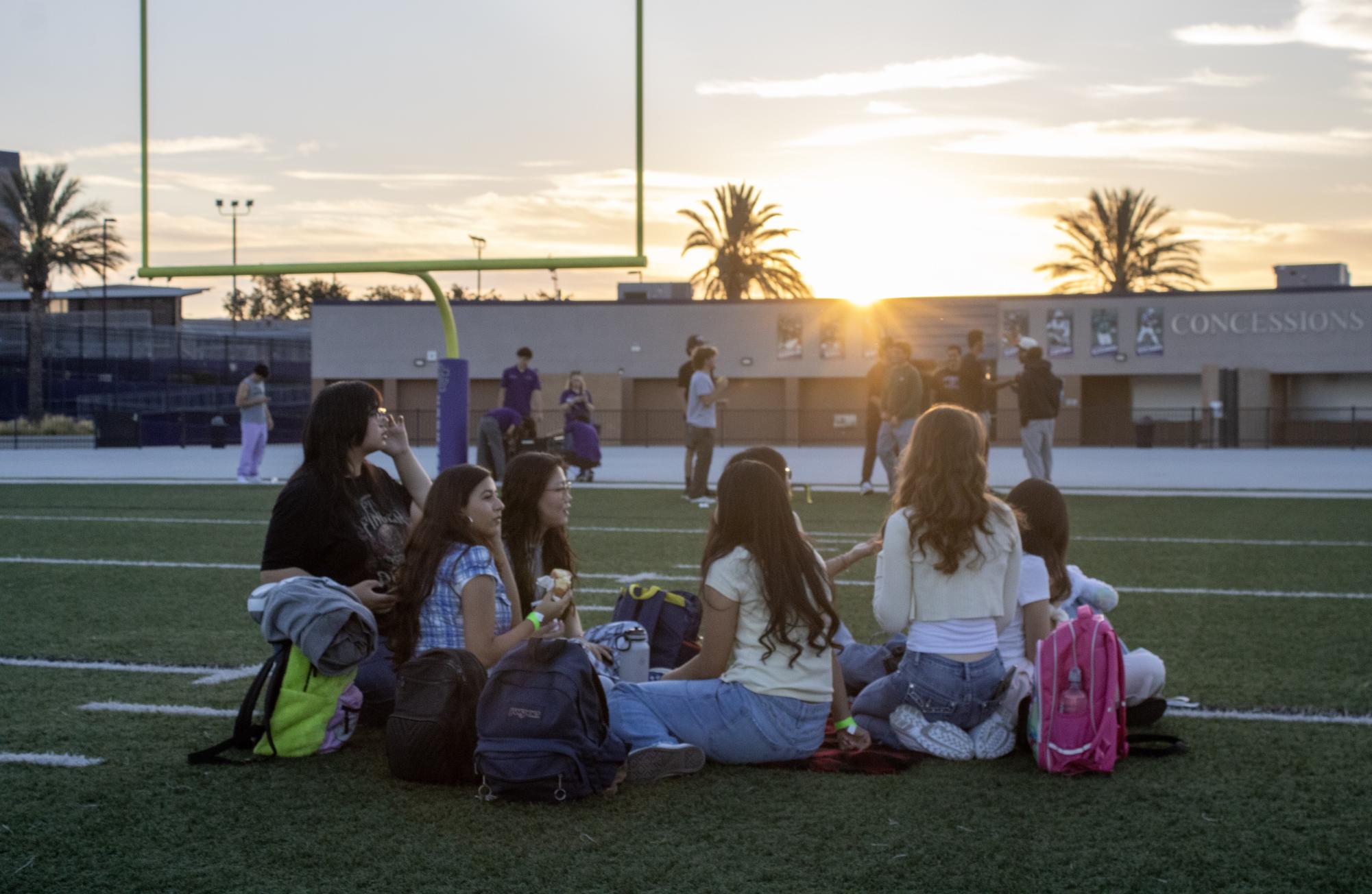 Groups of seniors gather with their friends on the Cougar Stadium's field to watch the sun begin to light up the sky at senior sunrise on Friday, Aug. 22.