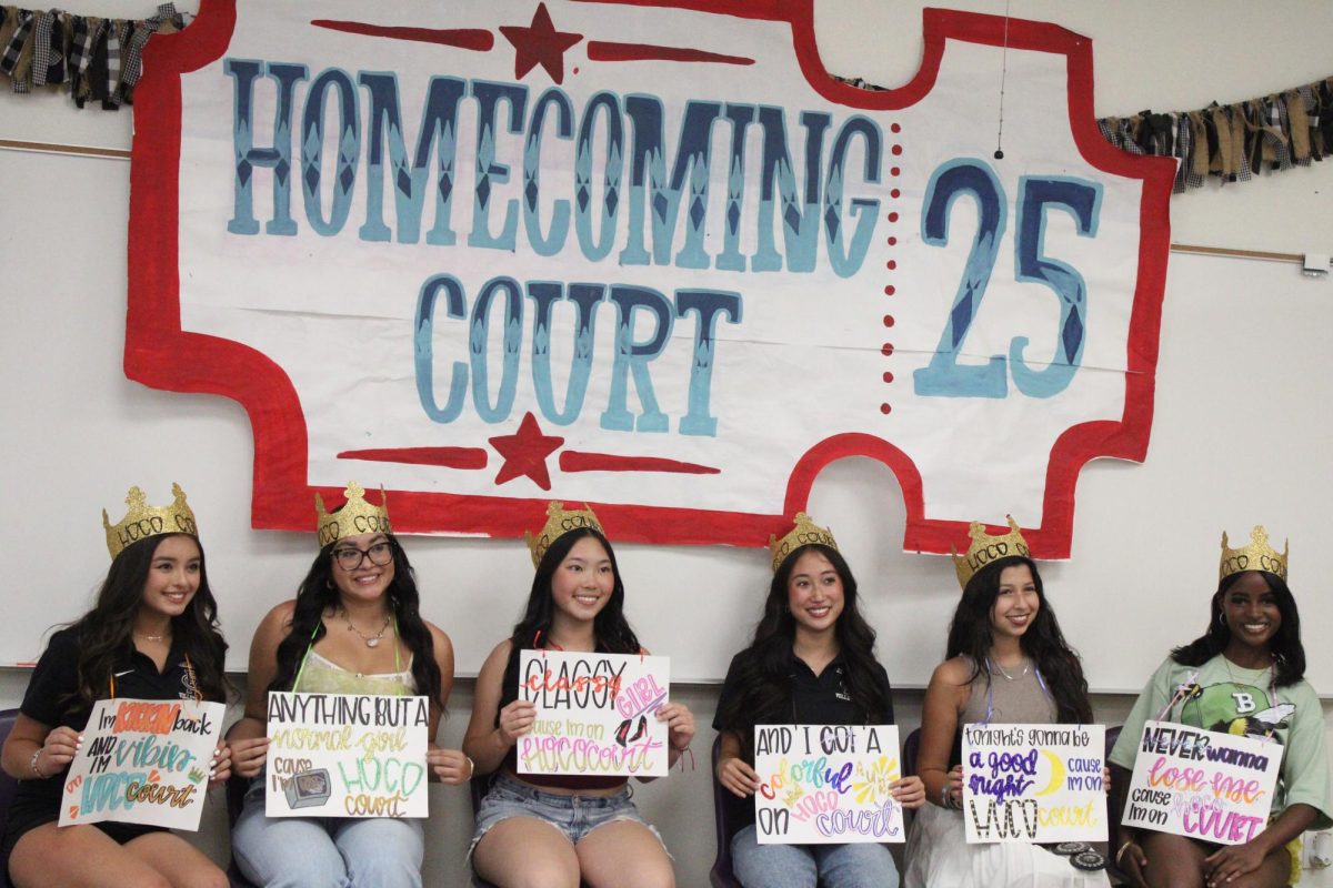 The RCHS 2025 homecoming princesses pose for a picture under sign made for them.