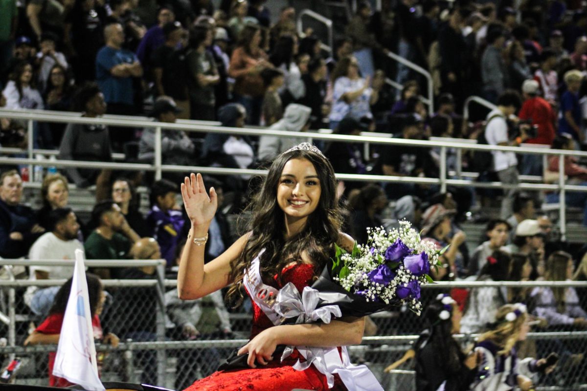 Princess number one, Isabella Duggins waves as she is riding around on a Corvette at the homecoming princess parade