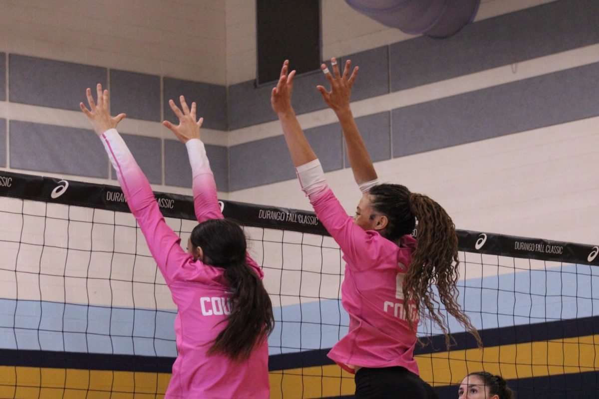 Senior Emily Smith and Junior Lyric Kelly go up to block the hit from the opposing team