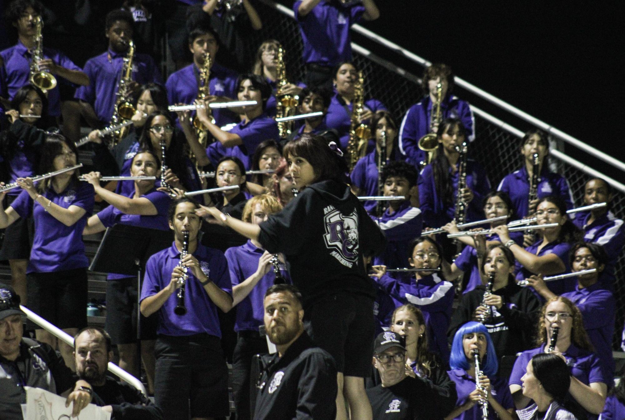 Rancho Cucamonga Marching Cougars' winds section plays for homecoming football game while drum major, senior Chloe Liu conducts.