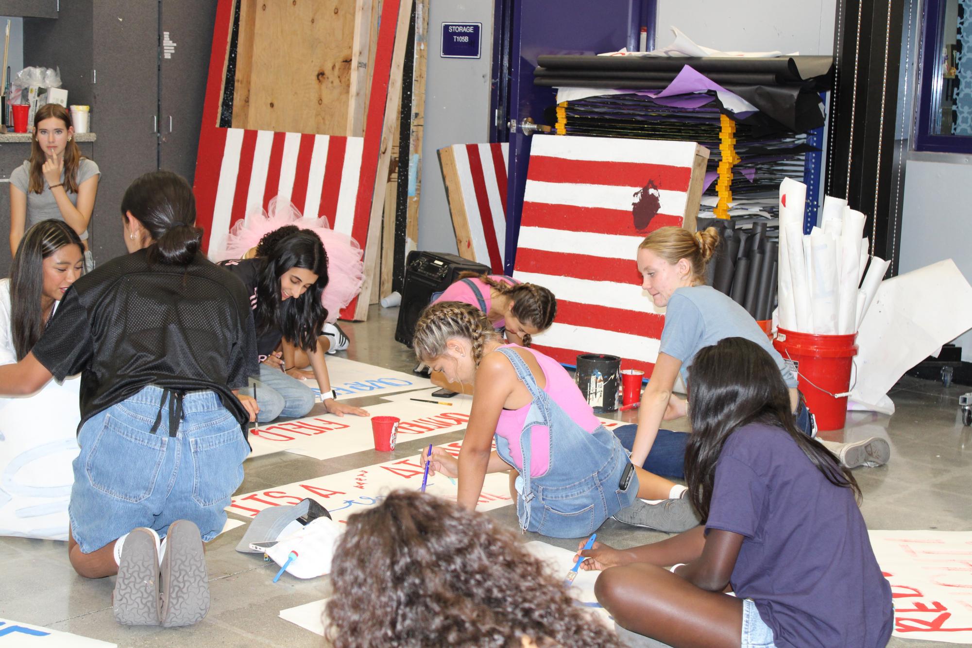 ASB students paint posters for the 2025 homecoming football game.