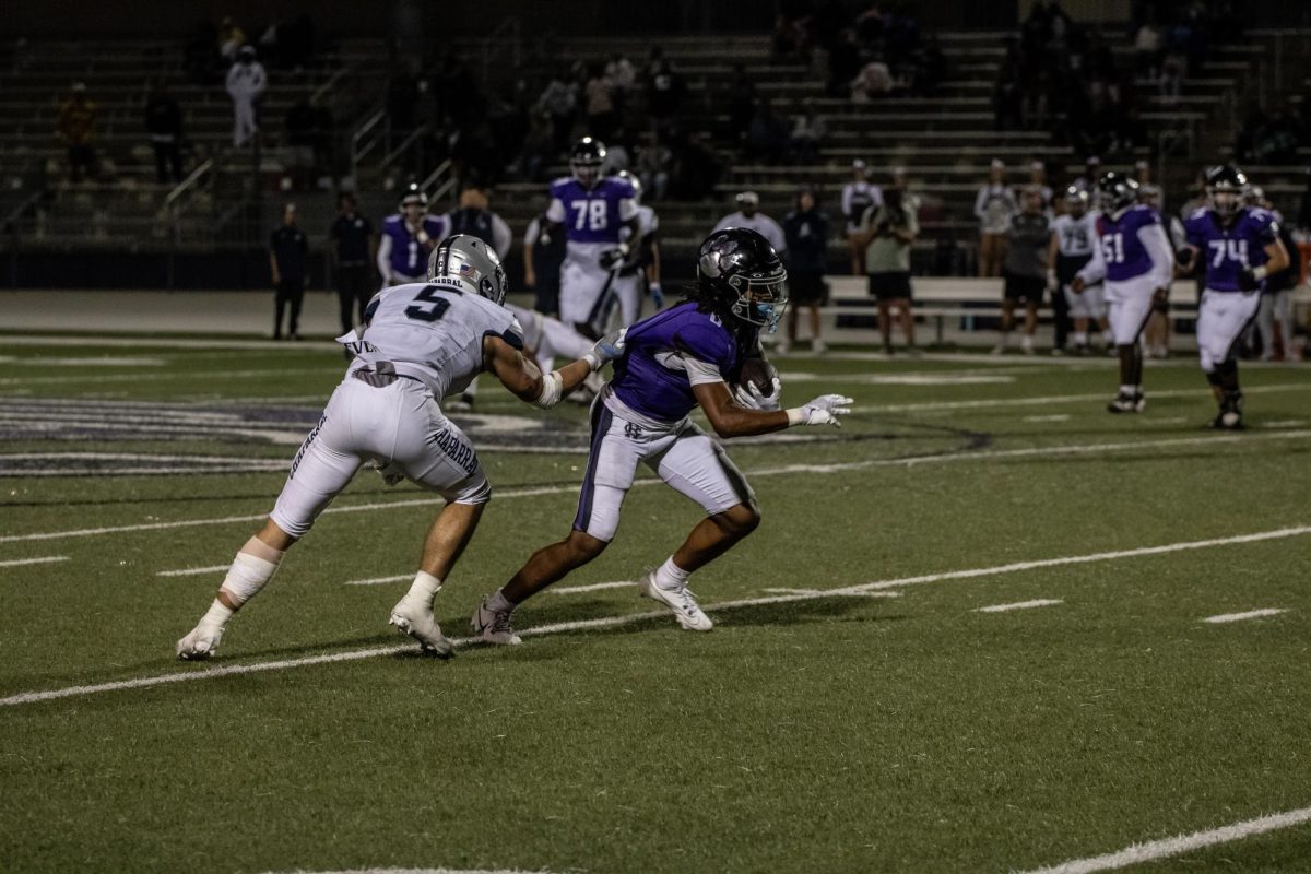 RCHS senior James Strong III is pushes past a Chaparral High School defensive back while holding on to his jersey.