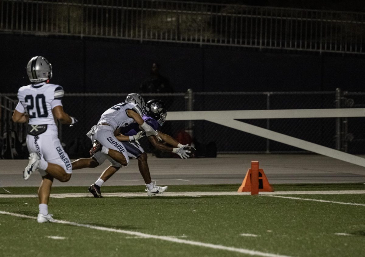 RCHS senior James Strong III extends the ball towards the endzone while having a Chaparral defender on his back, resulting in a touchdown.