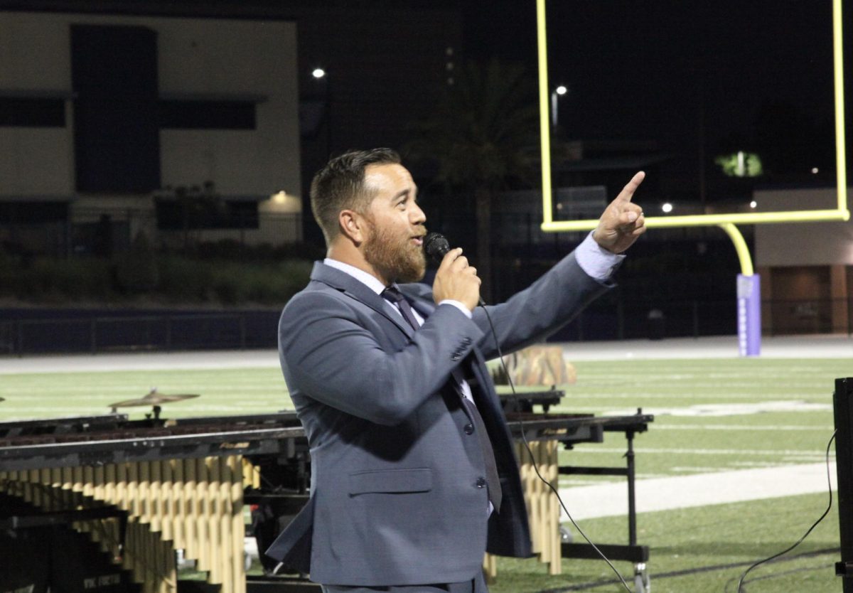 The band director, Mr. James Ana, points at the spectators during his welcome speech.