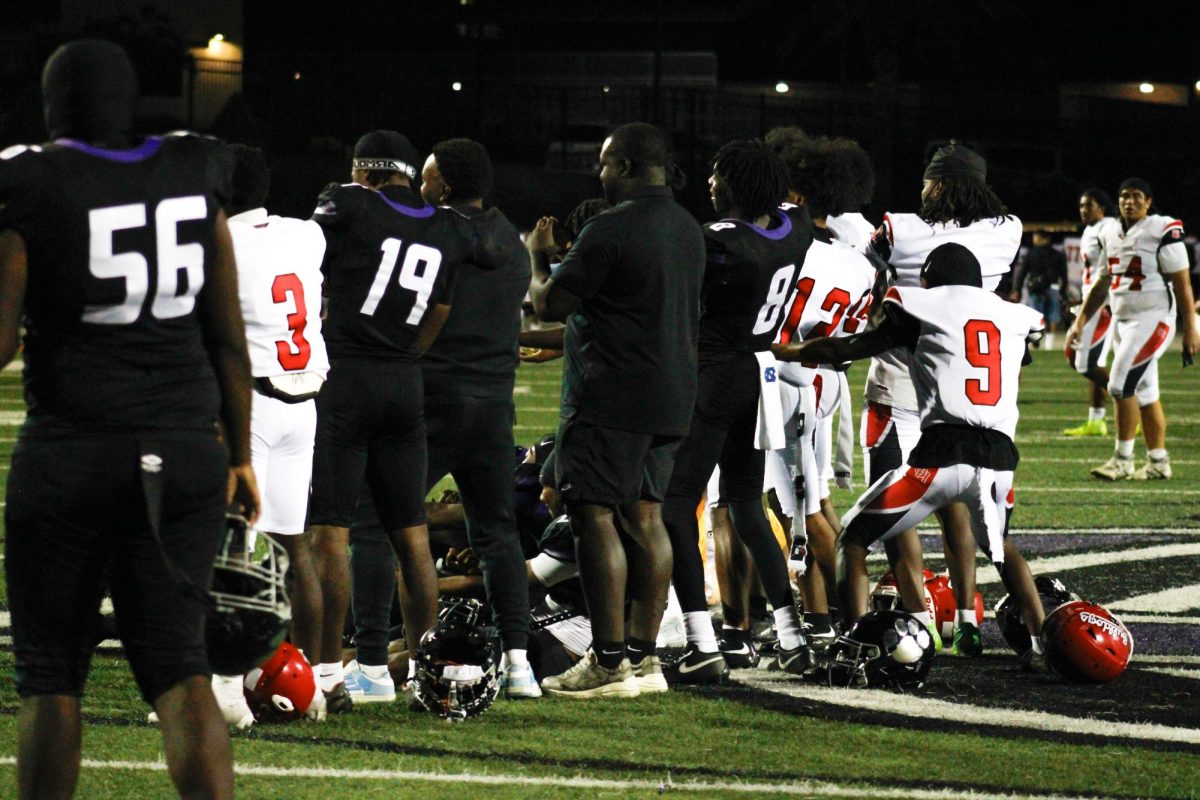 RCHS football players Andre Johnson II and Nate Mensah pose for a photo with several Oak hills players after the game.