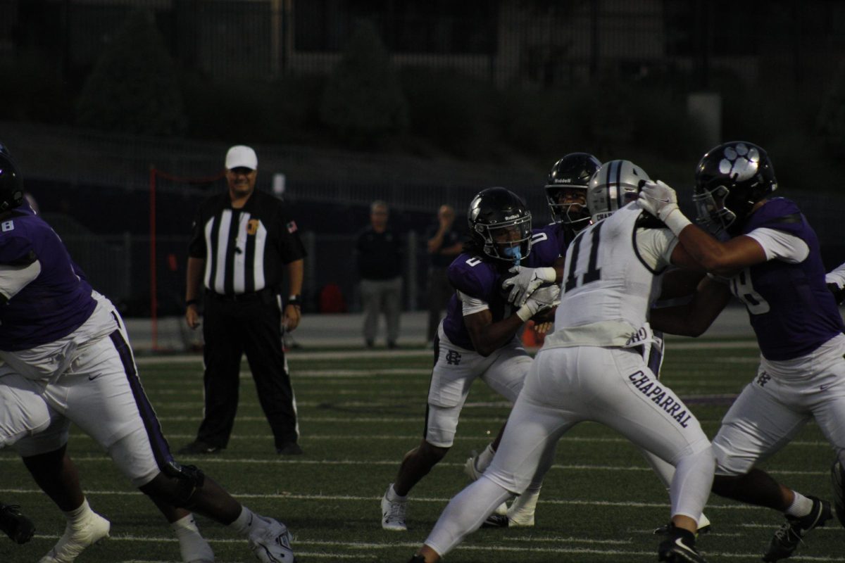 RCHS senior James Strong III grabs the ball from senior quarterback Jacob Chambers to penetrate Chaparral High School's defense.