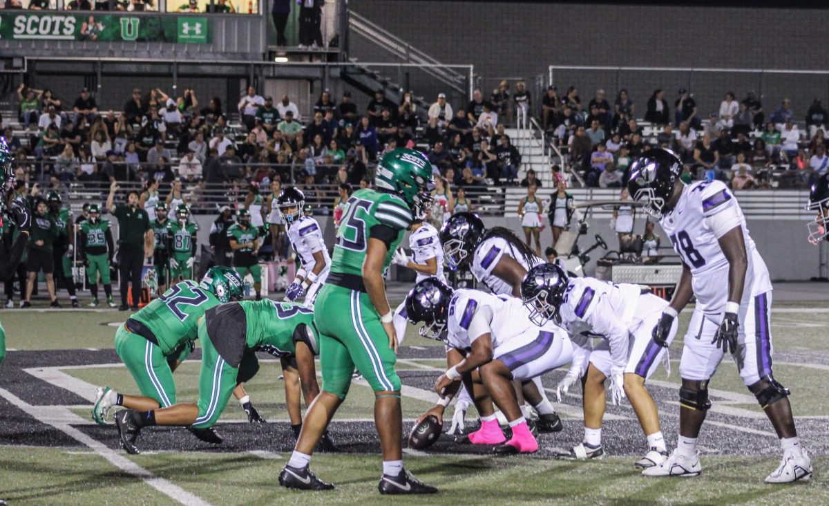 RCHS players line up on the Upland logo with the football in hand ready for the next play.