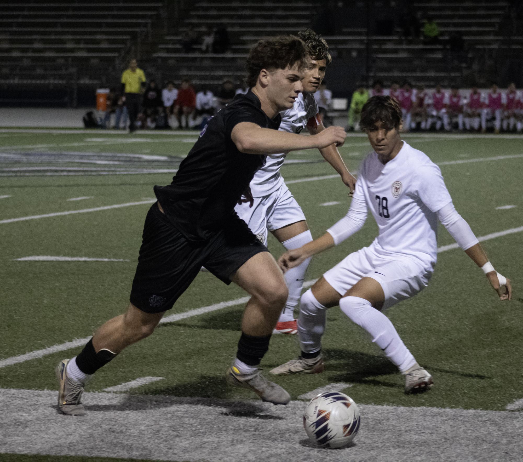 Senior Thomas Blank charges the ball down the sideline while escaping the feet of Etiwanda's team.