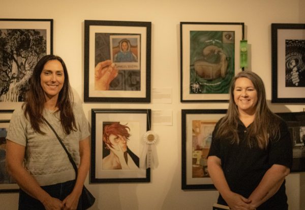 Art teachers Ms. Arrendando and Ms. Coon pose for a photo in front of Rancho students artwork.